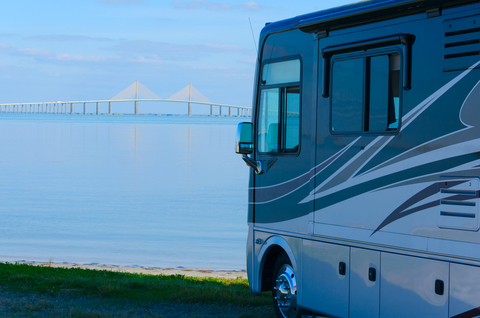 RV recreational vehicle is parked at the beach overlooking Tampa Bay in Florida with the Skyway Bridge in the background