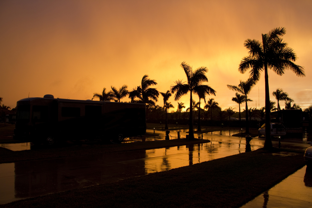 Class A motorhome with palm trees at sunset