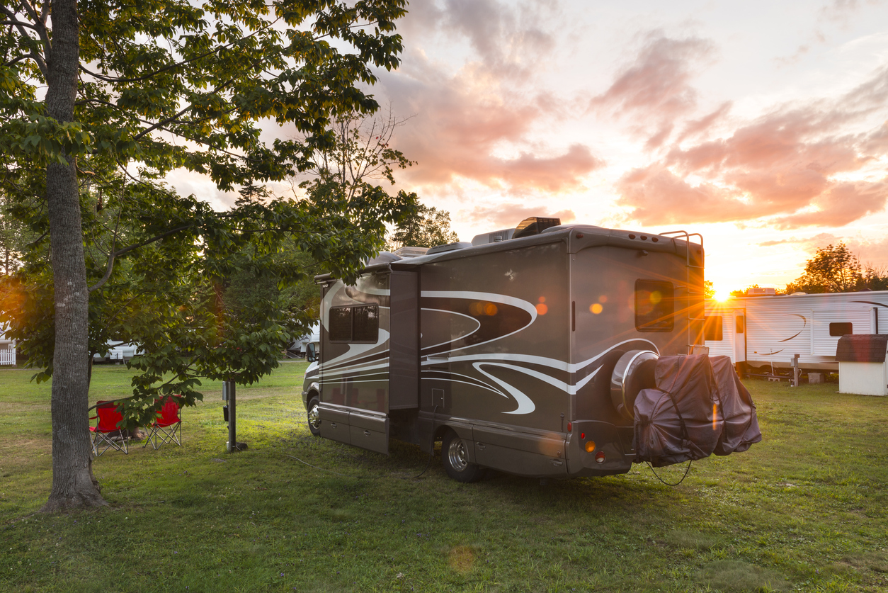 Our tips to how to save money on a new RV will get you the best price on RVs like this Class C, parked at a campground.