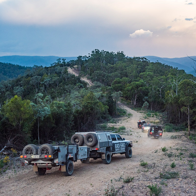 A Black Series overland trailer is towed up a mountain. These rigs are part of the overland classifieds available on RVUSA.