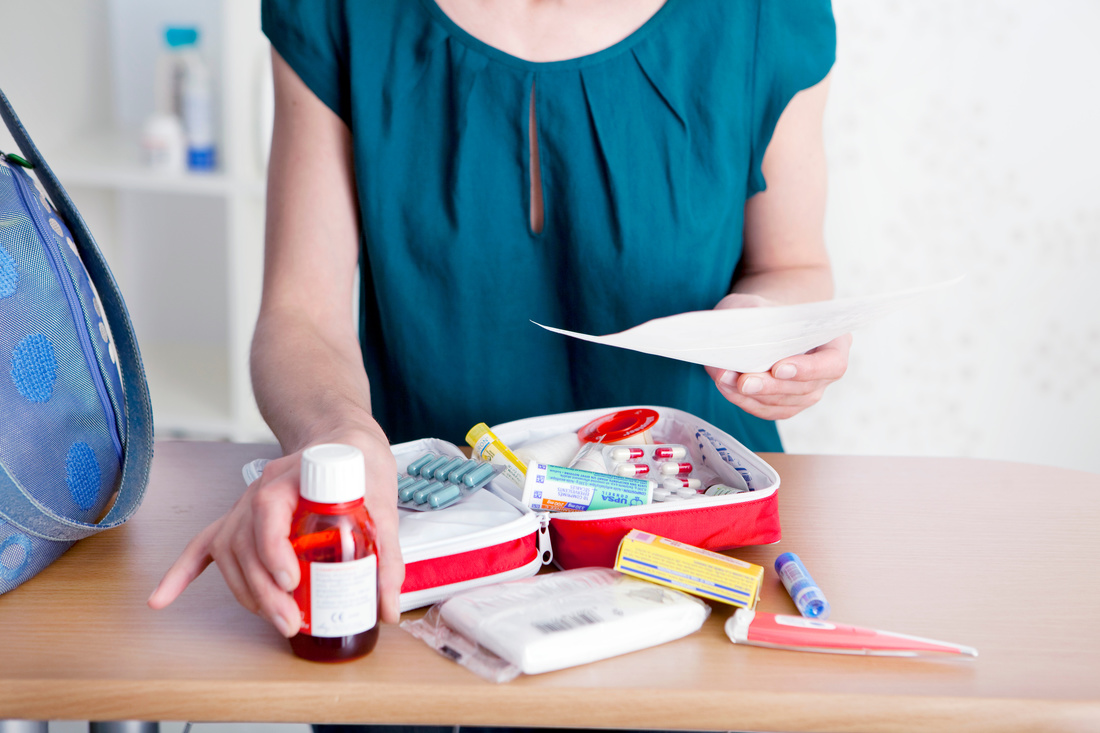 Woman packing a first aid kit from our RV packing kit. 