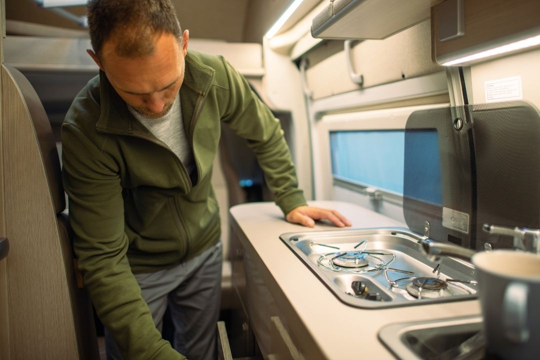 man cooking for two in a small rv