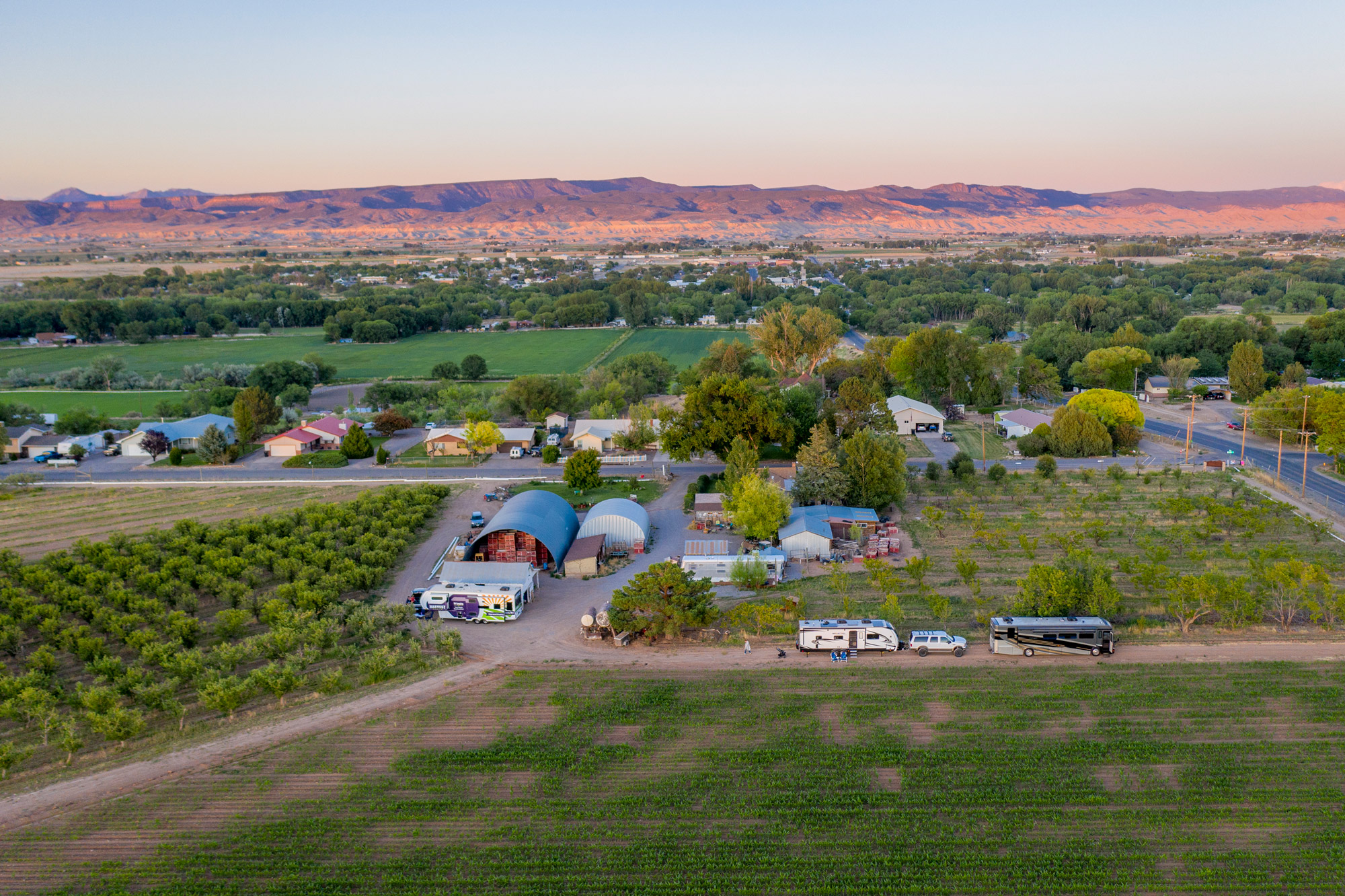 An overhead view of an RV camping at a winery in front of mountains
