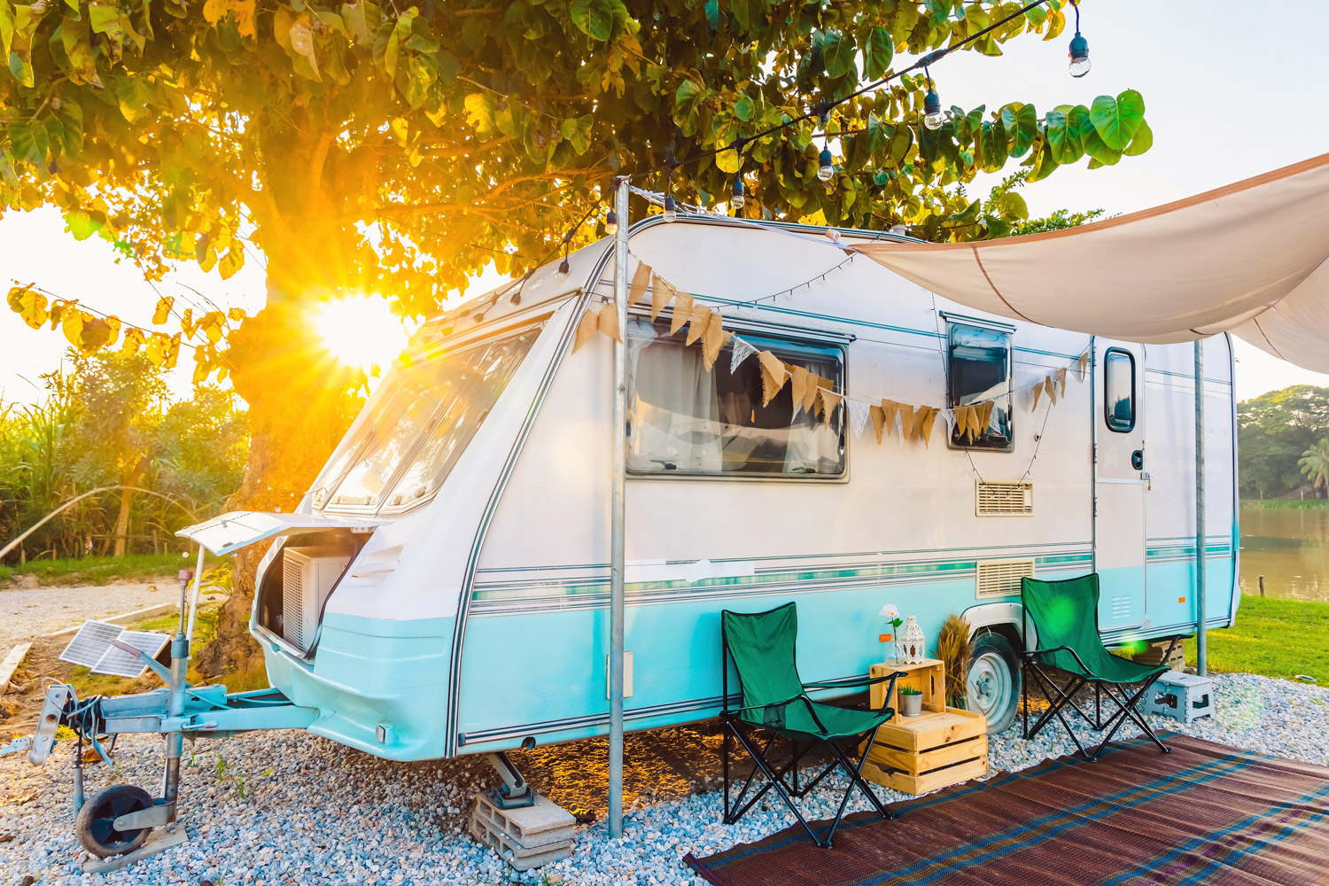 A used RV for sale by owner set up with patio and awning at sunset