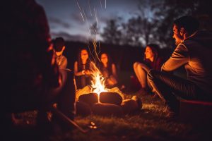 friends telling campfire stories at night