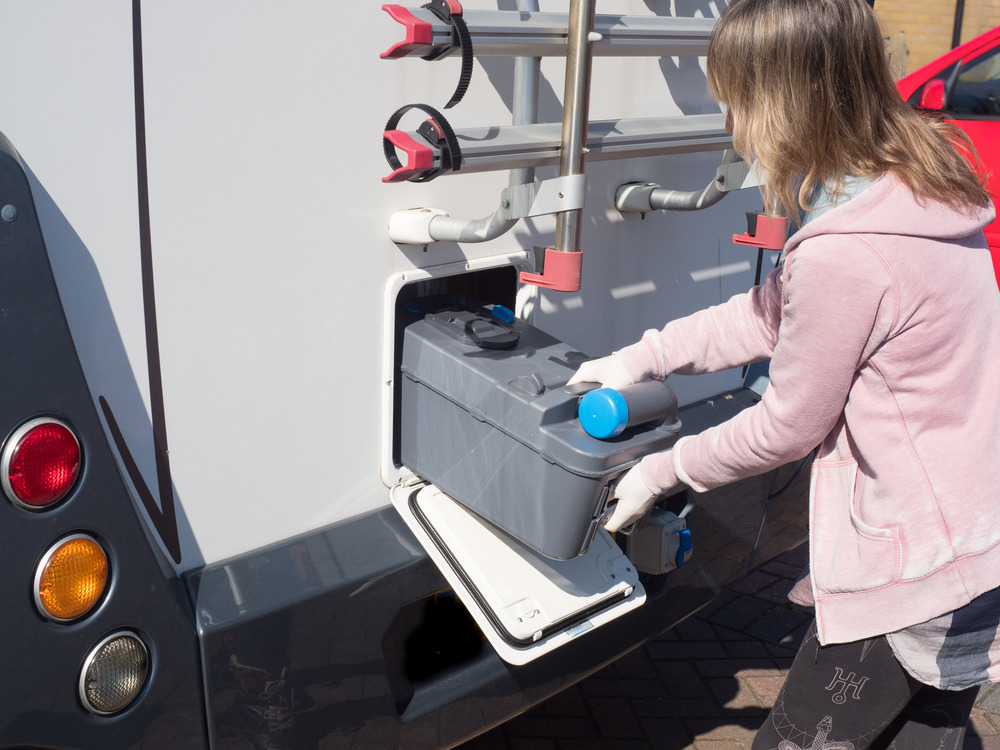 motorhome owner removes a cassette toilet from her motorhome to empty it