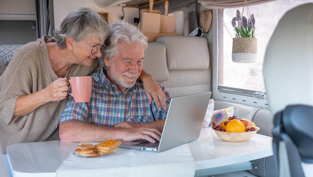 A couple on their laptop in an RV selling an RV online through RVUSA.