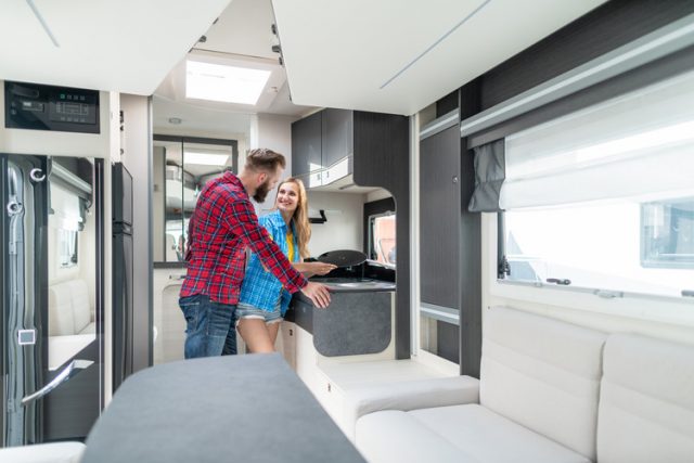Woman and man looking at the interior of an affordable RV they want to buy