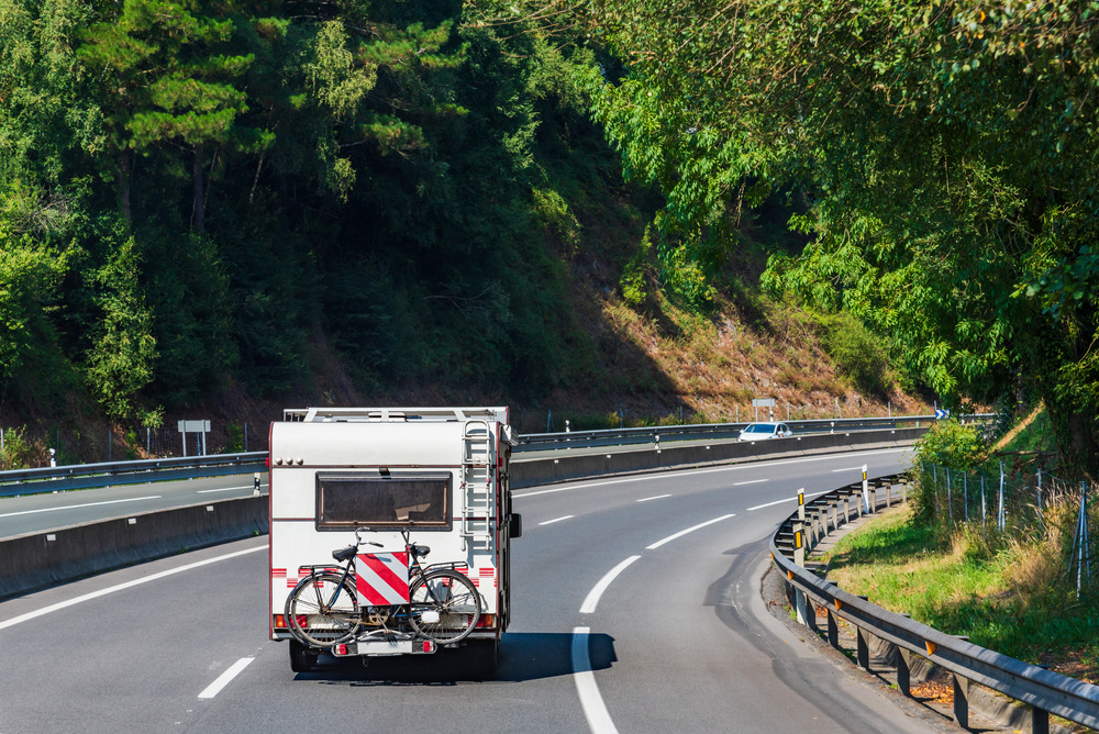 RV traveling to best places to travel during hurricane season with a bicycles behind it.