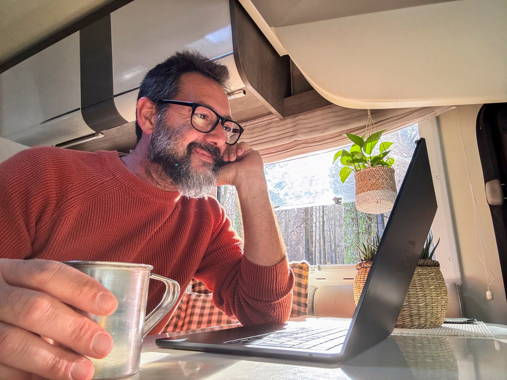 man working remotely while living in an RV full time to maintain his RV budget