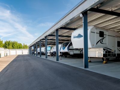 RVs lined up under an awning at an RV storage center.