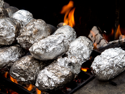 Baked Potatoes Wrapped in Foil Over The Campfire