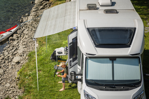 picture of and RV setting up camp by the river