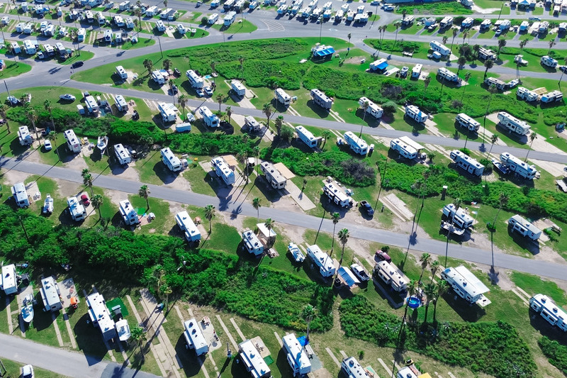 Large RV park campsite long row of recreational vehicles trailers boats tall palm trees in South Padre Island beach