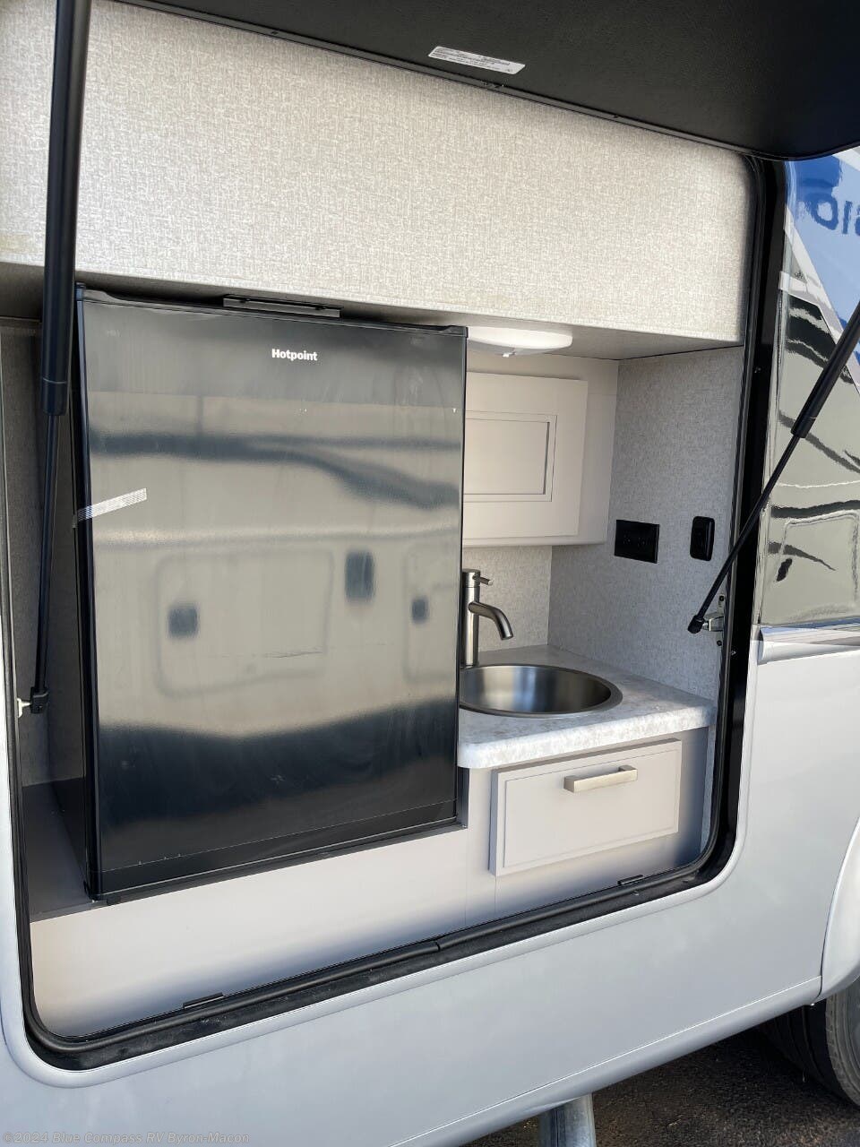 RV outdoor kitchen set up with a refrigerator and sink. 