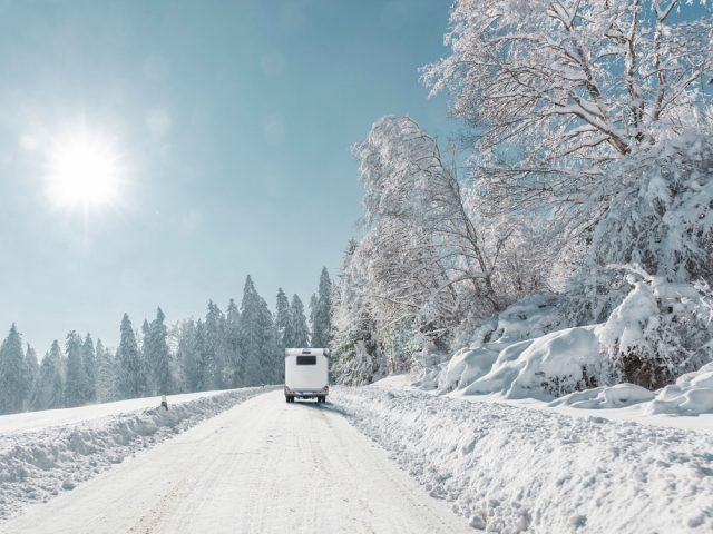 motorhome traveling down a snowy road during winter