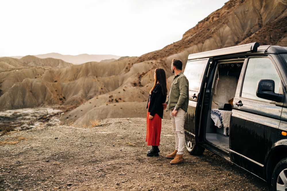 Couple enjoying scenic view from camper van in desert canyon