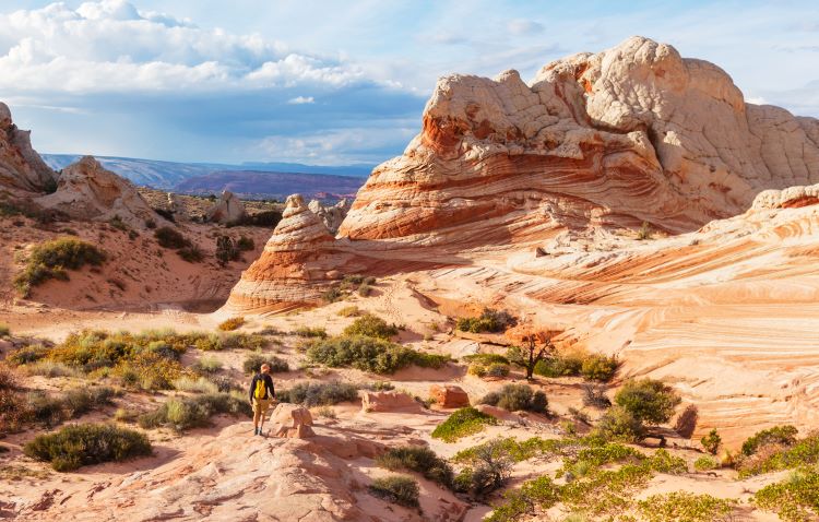 best parks in arizona to visit in your rv A man hiking White pocket<br />
at vermilion cliff in Arizona while on an RV trip