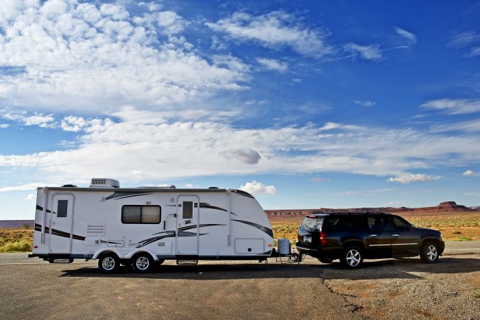 SUV and Travel Trailer A travel trailer hitched to a black SUV in the desert.