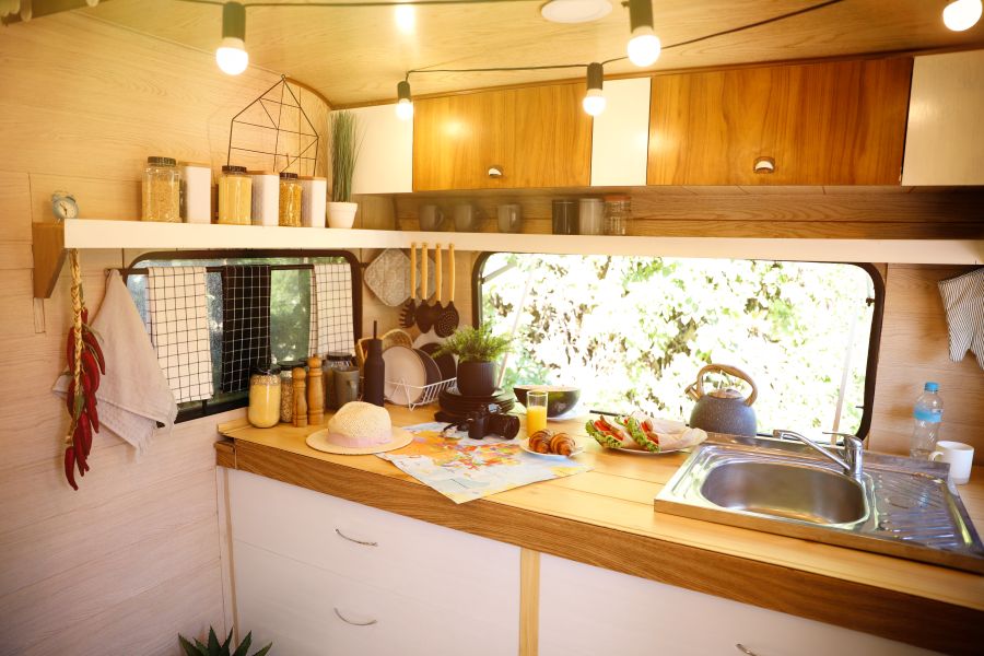 Stylish kitchen interior with different jars and utensils in modern trailer