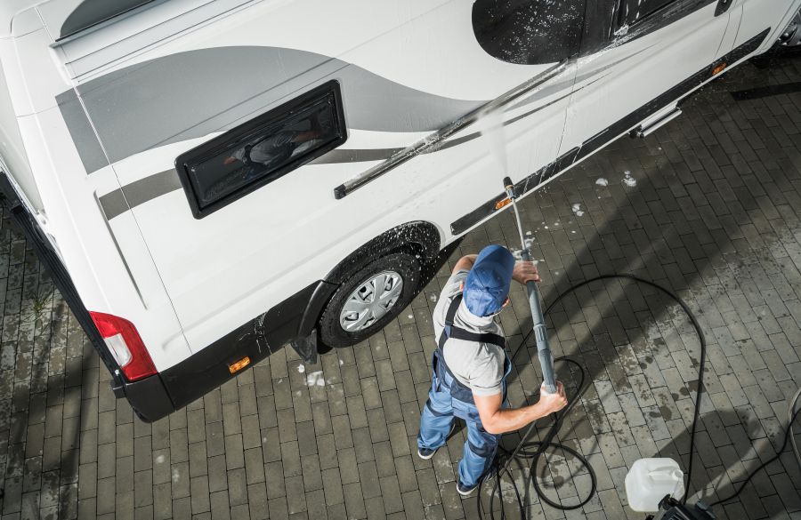 RV Service Worker Pressure Washing an RV