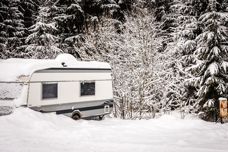 Travel trailer coverd in  a thick layer of snow