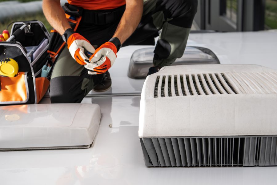 man on rv inspecting ac