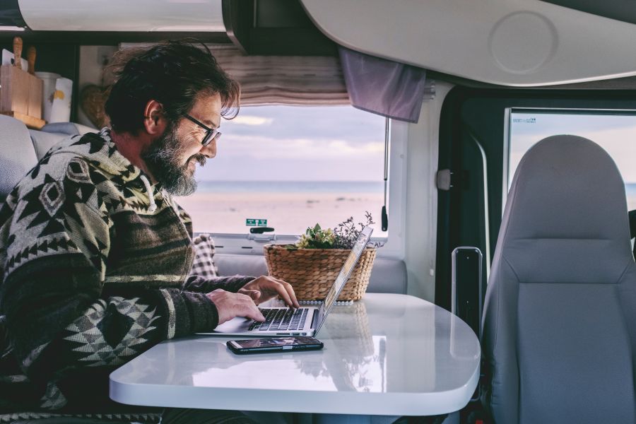  man use laptop computer to work inside rv