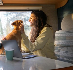 Single mother traveling with her son and dog in a motorhome and working on the laptop